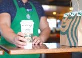 Starbucks barista handing cup of coffee to customer